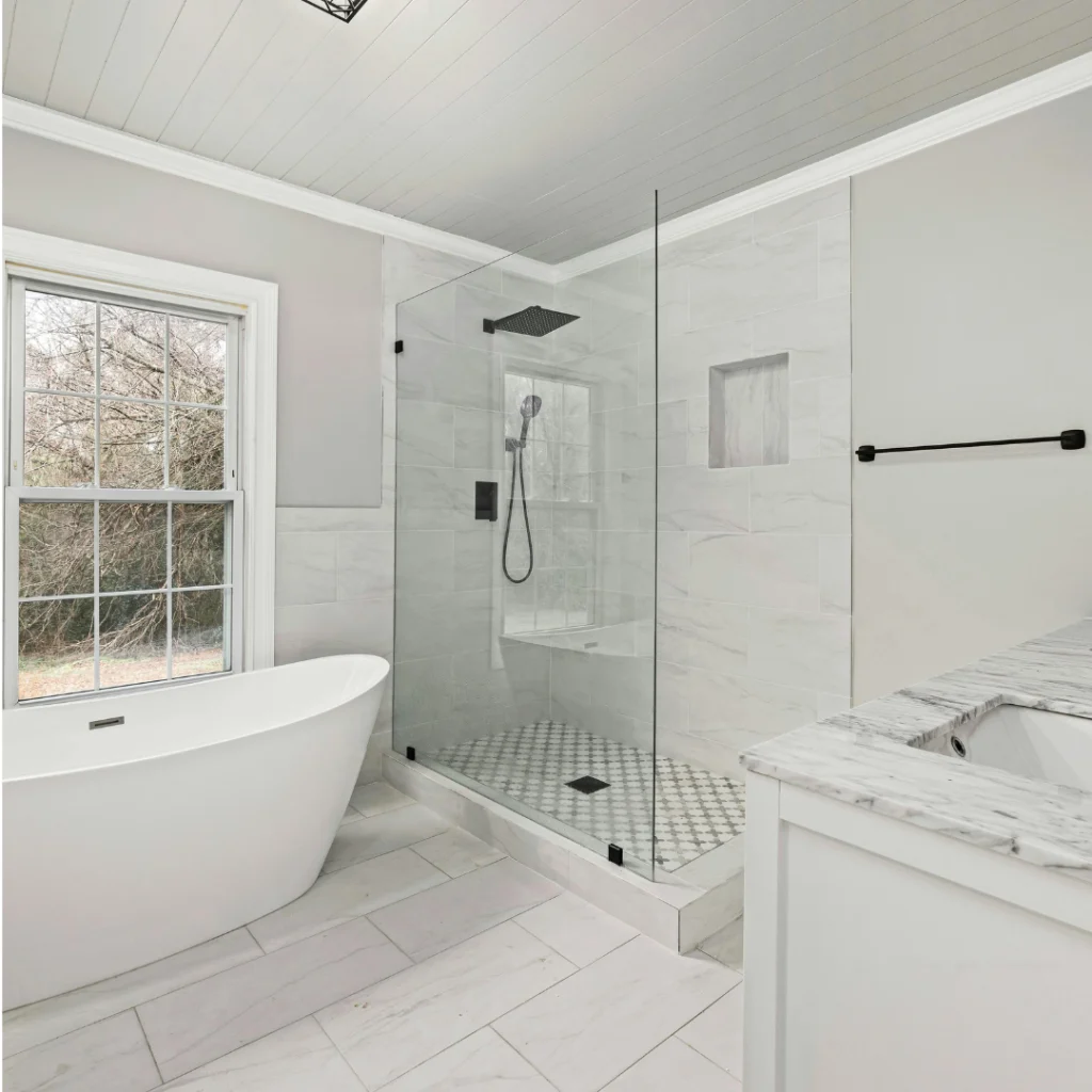 Bagno moderno con box doccia in vetro e rivestimenti effetto marmo; mobile lavabo scuro con specchi tondi e illuminazione a soffitto.